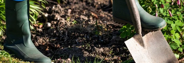 Person gräbt mit Spaten Erde um